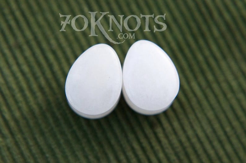 Puede incluir: Par de expansores de oreja de forma de l&aacute;grima blanca.