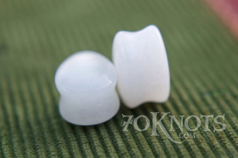 Puede incluir: Dos expansores de oreja redondos, opacos y blancos. Los expansores est&aacute;n hechos de un material liso y pulido.