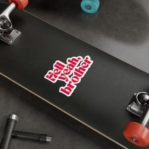 May include: A black skateboard with a white sticker that says "'zell yeah brother" in red and orange letters.