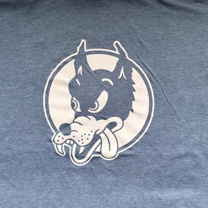 May include: A white wolf head with a tongue sticking out, in a cartoon style, is printed on a blue t-shirt.