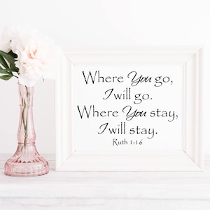 Puede incluir: Una impresi&oacute;n enmarcada en blanco con el texto "Where You go, I will go. Where You stay, I will stay. Ruth 1:16" en escritura negra. Un jarr&oacute;n de cristal rosa con flores blancas se encuentra a la izquierda del marco.