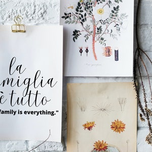 May include: A white poster with black calligraphy that reads "la famiglia &egrave; tutto" and the English translation "The family is everything."