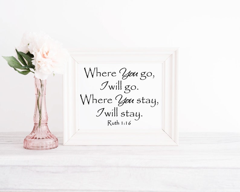 Puede incluir: Una impresi&oacute;n enmarcada en blanco con el texto "Where You go, I will go. Where You stay, I will stay. Ruth 1:16" en escritura negra. Un jarr&oacute;n de cristal rosa con flores blancas se encuentra a la izquierda del marco.