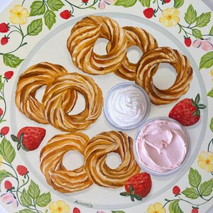 May include: A white plate with a decorative border of green leaves, yellow flowers, and red strawberries. The plate features five golden brown pastry rings, two small bowls of white and pink frosting, and four red strawberries.