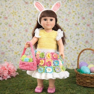 May include: A doll wearing a yellow crochet top, a floral skirt, and pink glitter shoes. The doll has a white headband with pink bunny ears and is holding a pink basket. A basket of Easter eggs is in the background.