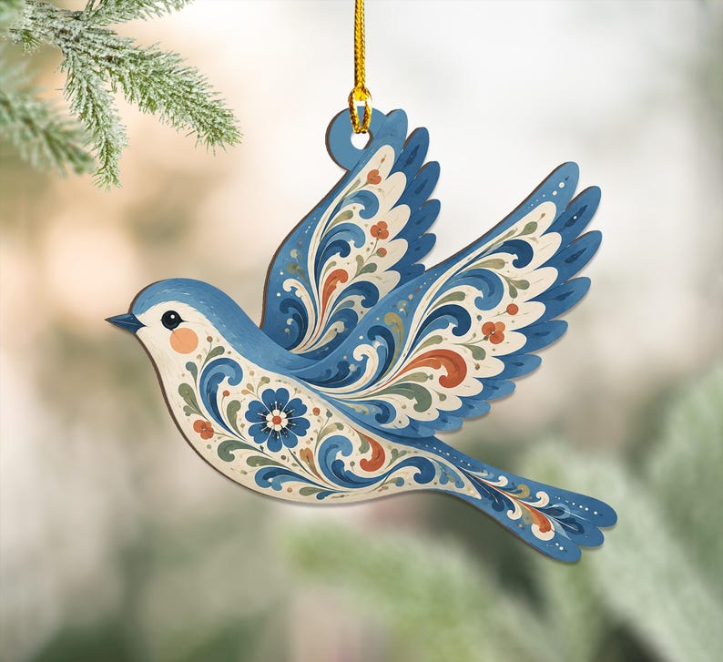 K&ouml;nnte beinhalten: Ein flacher, vogelformiger H&auml;ngeschmuck mit einem floralen Rankenmuster in Blau, Creme und Orange. Der Vogel ist im Flug mit nach oben ausgebreiteten Fl&uuml;geln dargestellt und an einer d&uuml;nnen goldenen Kordel befestigt, die durch ein Loch f&uuml;hrt.