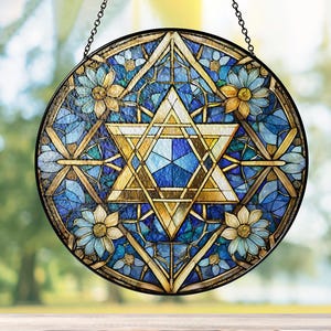 Pu&ograve; includere: Una finestra in vetro colorato appesa con un design a stella di David blu e oro. La stella &egrave; circondata da un motivo floreale.