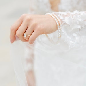 Bride holding pearl anklets in wedding dress