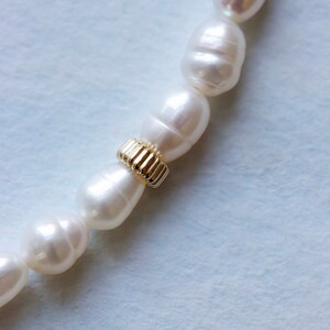 Closeup of handmade pearl anklet for wedding on light blue background