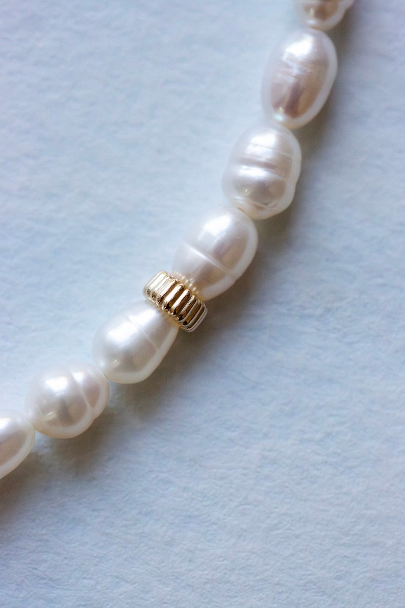 Closeup of handmade pearl anklet for wedding on light blue background