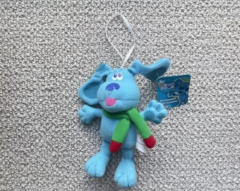 Könnte beinhalten: Plüsch-Anhänger von Blue's Clues mit einem grünen Schal und einem blauen, weißen und roten Etikett mit der Aufschrift "Blue's Clues Ornament".