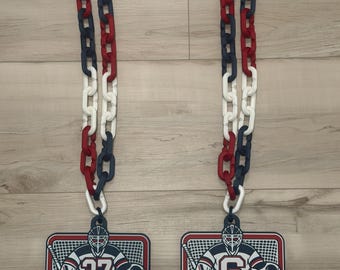 May include: Two sports medals featuring a goalie graphic with the numbers 37 and 6, the text GOALIE SHUT OUT NJC HOCKEY, and a red, white, and blue plastic chain. The rectangular medals display a hockey net, goalie gear, and a circular logo.