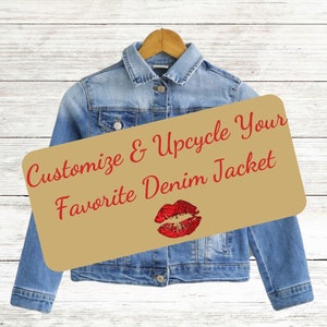 May include: A denim jacket hanging on a wooden hanger with a brown paper sign that says "Customize & Upcycle Your Favorite Denim Jacket" with a red glitter lip print.