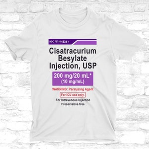 Könnte beinhalten: Weißes T-Shirt mit einem medizinischen Etikettendesign. Das Etikett zeigt den Text "Cisatracurium Besylate Injection, USP" und andere medizinische Informationen in Schwarz und Lila. Das Shirt hat einen Rundhalsausschnitt.