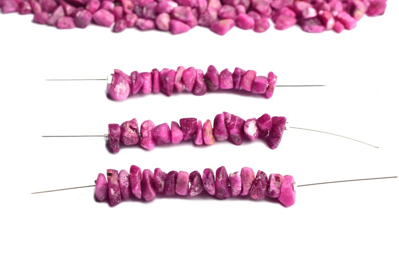 Assorted natural raw ruby stones in rough uncut form displayed on white background.