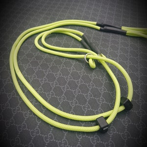 May include: A bright yellow dog leash with black hardware. The leash is made of a thick, durable rope.