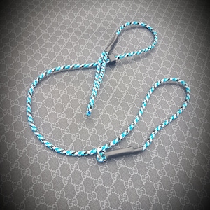 May include: A black and blue rope dog leash with a black handle.