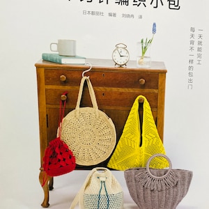 Puede incluir: Cinco bolsos de ganchillo en diferentes colores y estilos. Los bolsos se muestran en una mesa de madera con un reloj y un jarrón de flores. El texto en la página dice "趣味钩针编织小包", que se traduce como "Bolsa pequeña de ganchillo divertida".