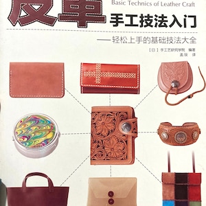 May include: A book cover with the title "Basic Technics of Leather Craft: Handmade Techniques for Beginners" in Japanese and English. The cover features various leather goods, including wallets, bags, and a bracelet.