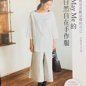 May include: A book cover featuring a woman wearing a white top and white trousers. The book title is "May Me" and the text reads "Naturally Made Clothes".