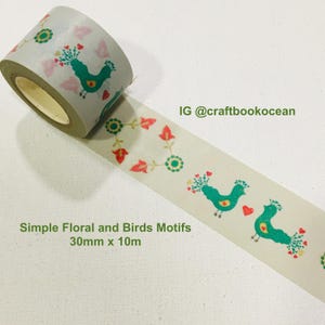 Könnte beinhalten: Eine Rolle cremefarbenes Washi-Tape mit einem sich wiederholenden Muster aus türkisfarbenen Vögeln, roten Herzen und Blumenmotiven. Das Band misst 30mm x 10m. Der Text auf dem Bild enthält IG @craftbookocean und Simple Floral and Birds Motifs 30mm x 10m.