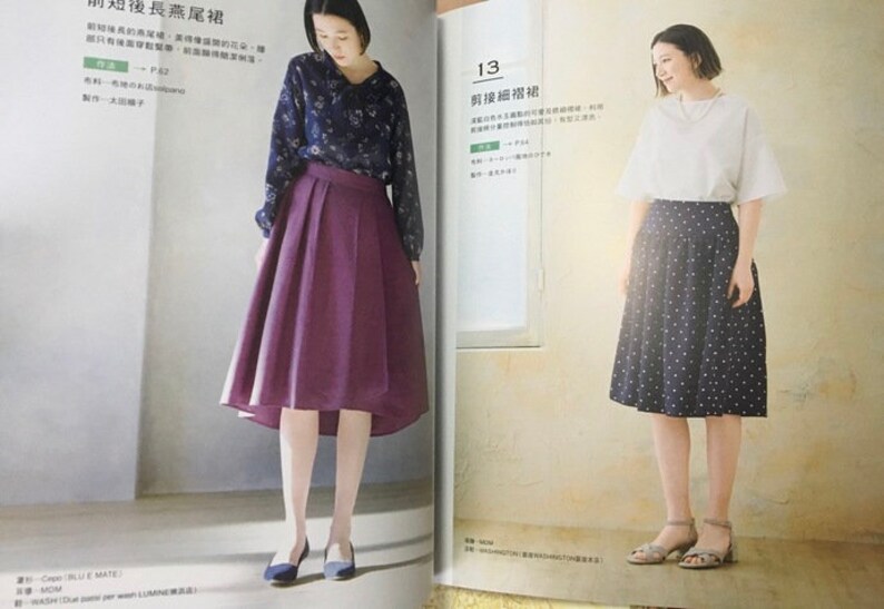 May include: Two women modeling outfits from a fashion magazine. One wears a dark blue floral blouse and a pleated purple skirt. The other wears a white top and a navy skirt with white polka dots. The magazine pages are open.