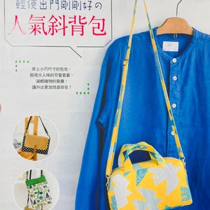 May include: A yellow and blue patterned crossbody bag with a matching strap hangs against a blue shirt. The bag has a rectangular shape with a top handle. Text in Japanese reads "Popular Crossbody Bag" and other text.
