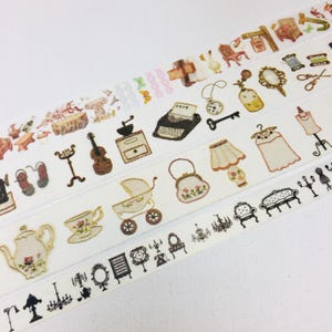 May include: Decorative washi tape rolls featuring vintage-style illustrations. The designs include furniture, accessories, and household items in soft colors. The tape is ideal for scrapbooking, crafting, and adding a touch of nostalgia to projects.