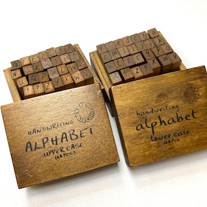 Una caja de 28 sellos de goma de madera con letras del alfabeto inglés: mayúsculas o minúsculas