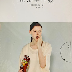 May include: A woman wearing a white shirt is holding a bag of potato chips. The bag is brown with yellow and white text. The text on the bag reads "VON BROWN", "NID", "UKA", "RISP". The background is a light gray color. The image also includes a black and white diagram of a circle.