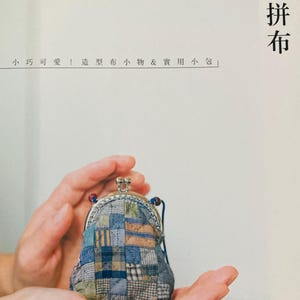 May include: A close-up of a small, patchwork fabric coin purse with a silver clasp. The purse is held in the hands of a person. The text "斉藤謠子の掌心拼布" is visible in the background.