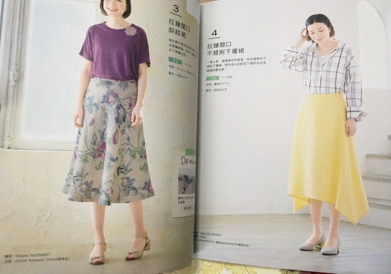 May include: Two women modeling clothing from a fashion magazine. One wears a purple t-shirt and floral skirt. The other wears a plaid shirt and yellow skirt. The magazine pages are open, displaying text and illustrations.