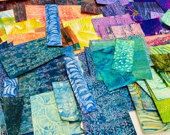 Peut inclure: Un ensemble de morceaux de papier colorés et à motifs dans différentes nuances de bleu, vert, violet et orange. Le papier est disposé de manière aléatoire, créant un design visuellement intéressant et abstrait.