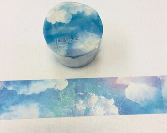 May include: A roll of washi tape with a watercolor design of blue clouds on a white background. The tape is labeled "晴朗的天空" which translates to "Clear Sky" in English.
