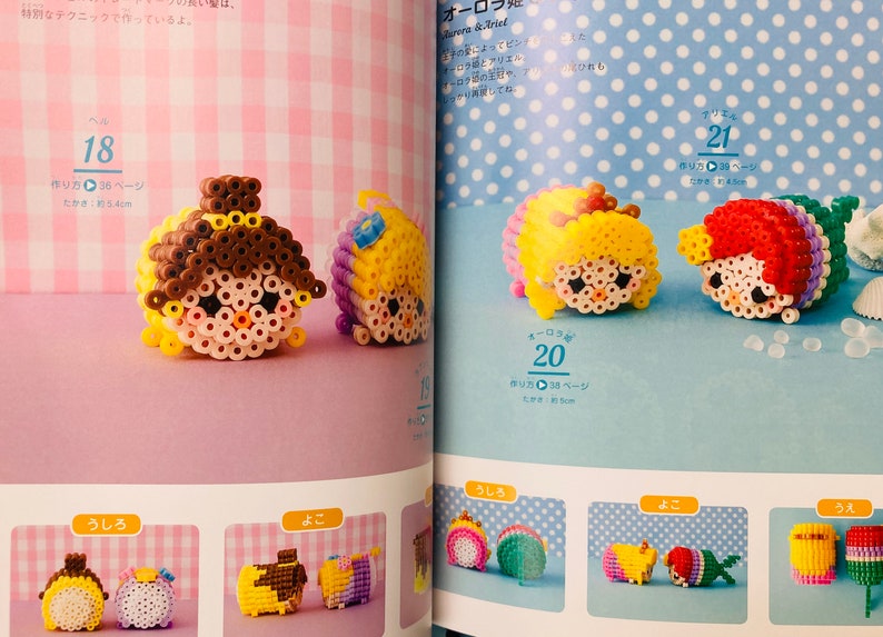 May include: A book with instructions on how to make bead sprites of Disney princesses. The book shows images of completed bead sprites of Belle, Cinderella, Rapunzel, and Ariel. The book is open to a page with the title "Aurora & Ariel".