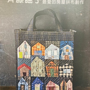 May include: A book cover featuring a blue and grey tote bag with a patchwork design of colourful houses. The title of the book is "斉藤謠子  屋拼布創作" which translates to "Saito Yōko House Patchwork Creation". The book includes two large-sized pattern sheets and instructions.