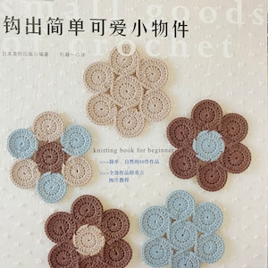 May include: A book titled "钩出简单可爱小物件" (Hook Out Simple Cute Little Things) with a cover featuring crocheted flower designs in brown, beige, and blue. The book is a knitting book for beginners and includes 50 crochet projects.