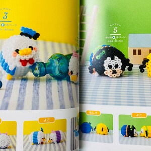 May include: A book with instructions on how to make bead sprites. The book features colourful bead sprites of popular cartoon characters. The book is open to a page showing instructions for making a bead sprite of a duck character. The page also shows a bead sprite of a duck character, a bottle, and a bead sprite of a character with a flower.