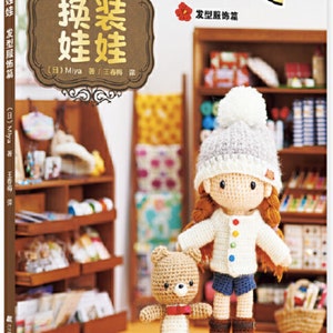 May include: A book cover featuring a crocheted doll and teddy bear. The book title is "换装娃娃" in Chinese characters. The book cover is a light brown color with a wooden shelf in the background.