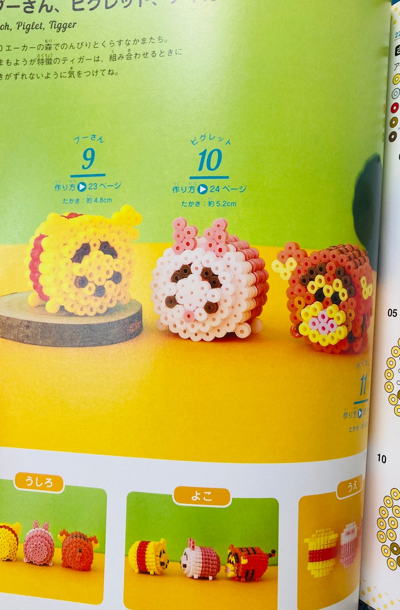 May include: Three colourful bead sprites of Winnie the Pooh, Piglet, and Tigger. The sprites are made with small, round beads in various colours, including yellow, pink, red, brown, and black. The sprites are approximately 5 cm tall. The image includes instructions for making the sprites, with the text "作り方" (Japanese for "how to make") and page numbers.