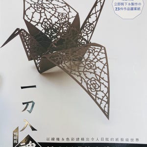Op de afbeelding: Een bruine papieren origami-kraanvogel met ingewikkelde uitgesneden ontwerpen van rozen en doornen. De kraanvogel heeft de titel "鏤空紙雕的立體美雕塑", wat vertaald "Driedimensionale sculptuur van papiersnijwerk" betekent.