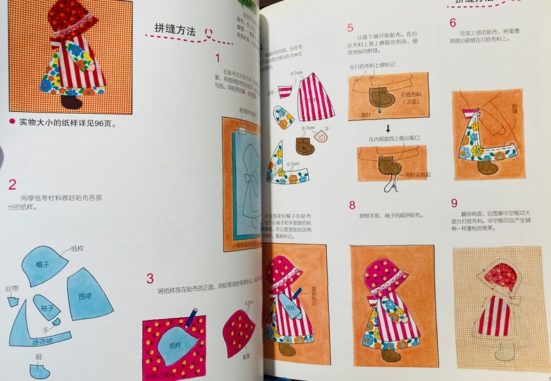 Pode incluir: Um livro com instru&ccedil;&otilde;es sobre como fazer uma boneca de patchwork. O livro est&aacute; aberto em uma p&aacute;gina que mostra uma boneca com um vestido de listras vermelhas e brancas, um avental com estampa floral e sapatos marrons. A p&aacute;gina tamb&eacute;m mostra as diferentes pe&ccedil;as de tecido que s&atilde;o necess&aacute;rias para fazer a boneca.