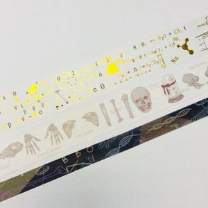 May include: Three rolls of washi tape with different designs. The first roll features a gold chemical formula and a yellow beaker. The second roll features a skull, a bone, and a glass jar with a red ribbon. The third roll features a black and white pattern of DNA strands.