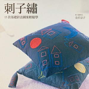 May include: A book titled "刺子繡" (Sashiko Embroidery) with a blue and white cover featuring two embroidered pillows. The book is written in Japanese and includes the text "15款基礎針法圖案輕鬆學" (15 Easy-to-Learn Basic Stitch Patterns) and "刺子繡專家 金沢京子" (Sashiko Embroidery Expert Kanazawa Kyoko).