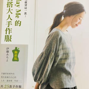 May include: A book cover with a woman wearing a gray and white striped shirt. The book title is "May Me's Popular Edition: Easy-to-Make Adult Clothing." The book cover also features a drawing of a dress form with the text "Popular Edition" in Japanese.