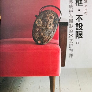 Op de afbeelding: Een boek getiteld "無框・不設限" met Japanse tekst die vertaalt naar "Frameless - No Limits". De omslag van het boek toont een close-up van een kleine, zeshoekige tas gemaakt van stofresten, rustend op een rode fluwelen stoel.
