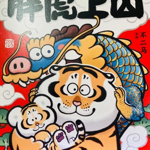 Peut inclure: Une illustration colorée d'une famille de tigres avec un dragon en arrière-plan. Le tigre tient un petit tigre. Le texte sur la couverture est "胖虎上山" en caractères chinois.