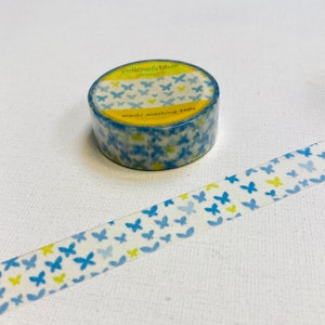 May include: A roll of washi tape with a pattern of blue and yellow butterflies on a white background. The tape is labelled "yellow&blue" and "washi masking tape".