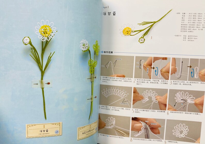 May include: A book with instructions on how to make a chamomile flower using thread. The book is open to a page with a diagram of the flower and instructions in Japanese. The book also includes a picture of a finished chamomile flower.