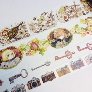 May include: Four rolls of decorative washi tape featuring vintage illustrations of keys, cameras, flowers, and girls. The tape is white with a light brown background.